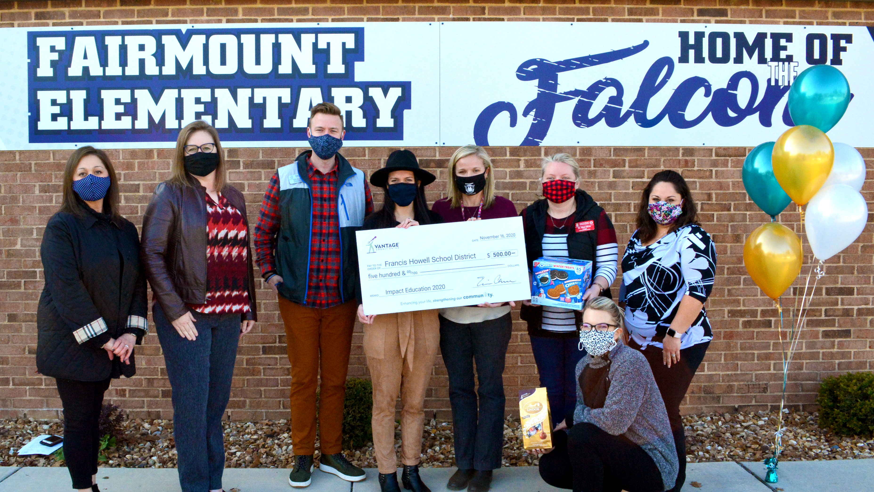 A group of teachers holding a large check