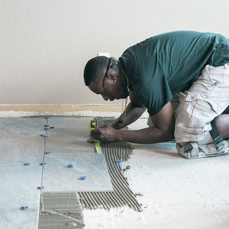 A contractor installing tile