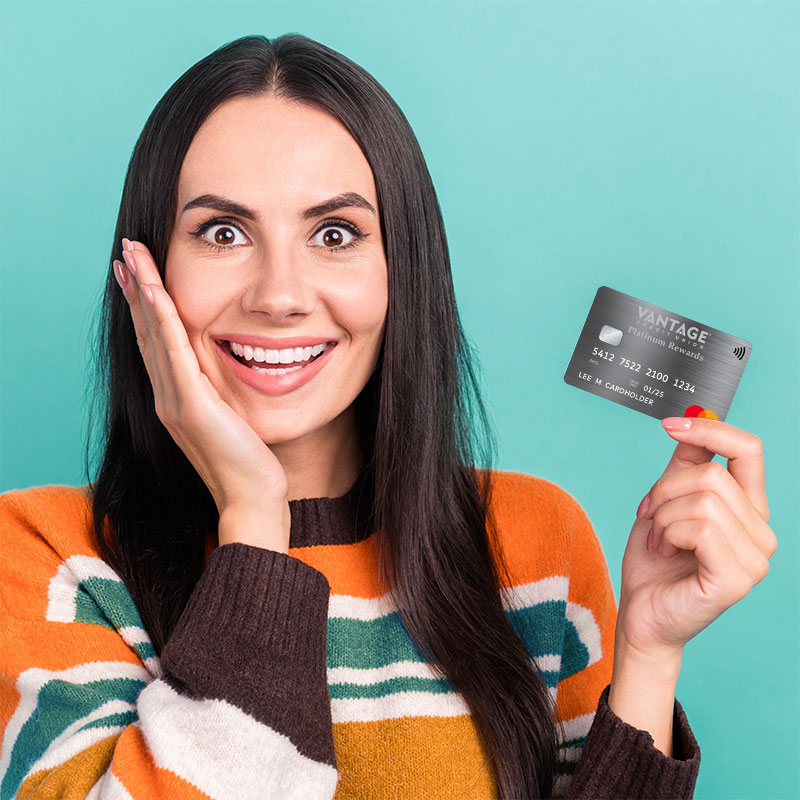 A woman smiling holding a credit card