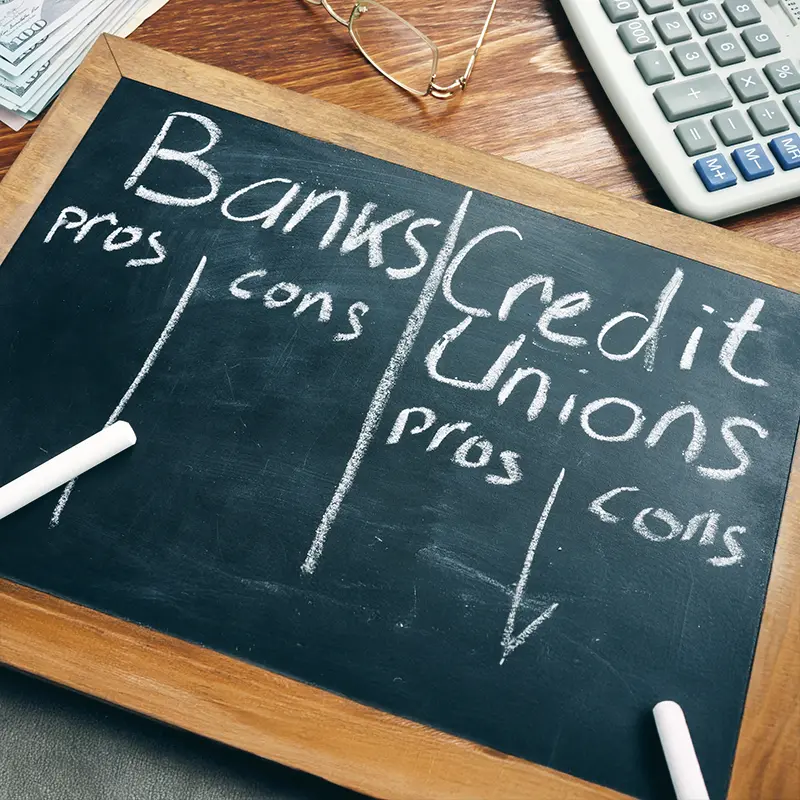 Chalkboard listing pros and cons of banks and credit unions
