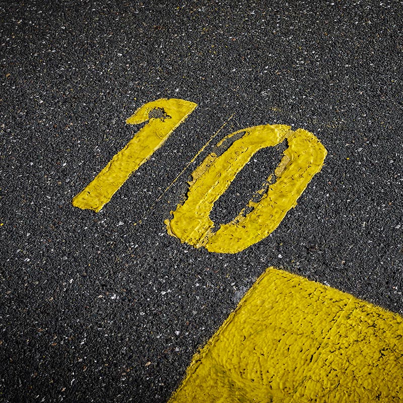 A yellow number 10 written on asphalt