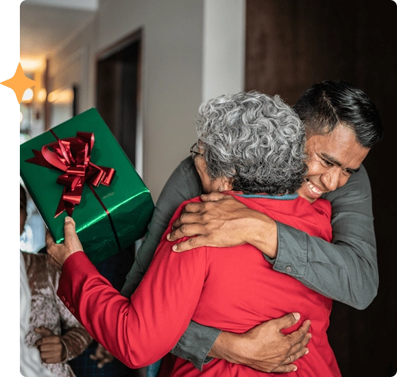 A mother and son hugging and holding a christmas present