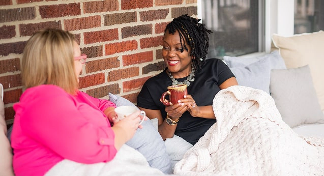 Two people having a conversation on a front porch